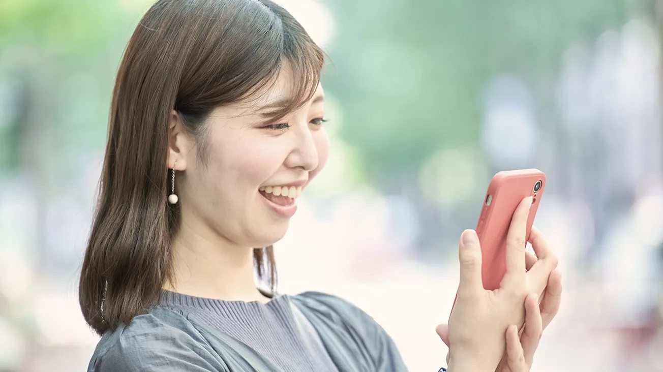 スマートフォンで情報をチェックする女性